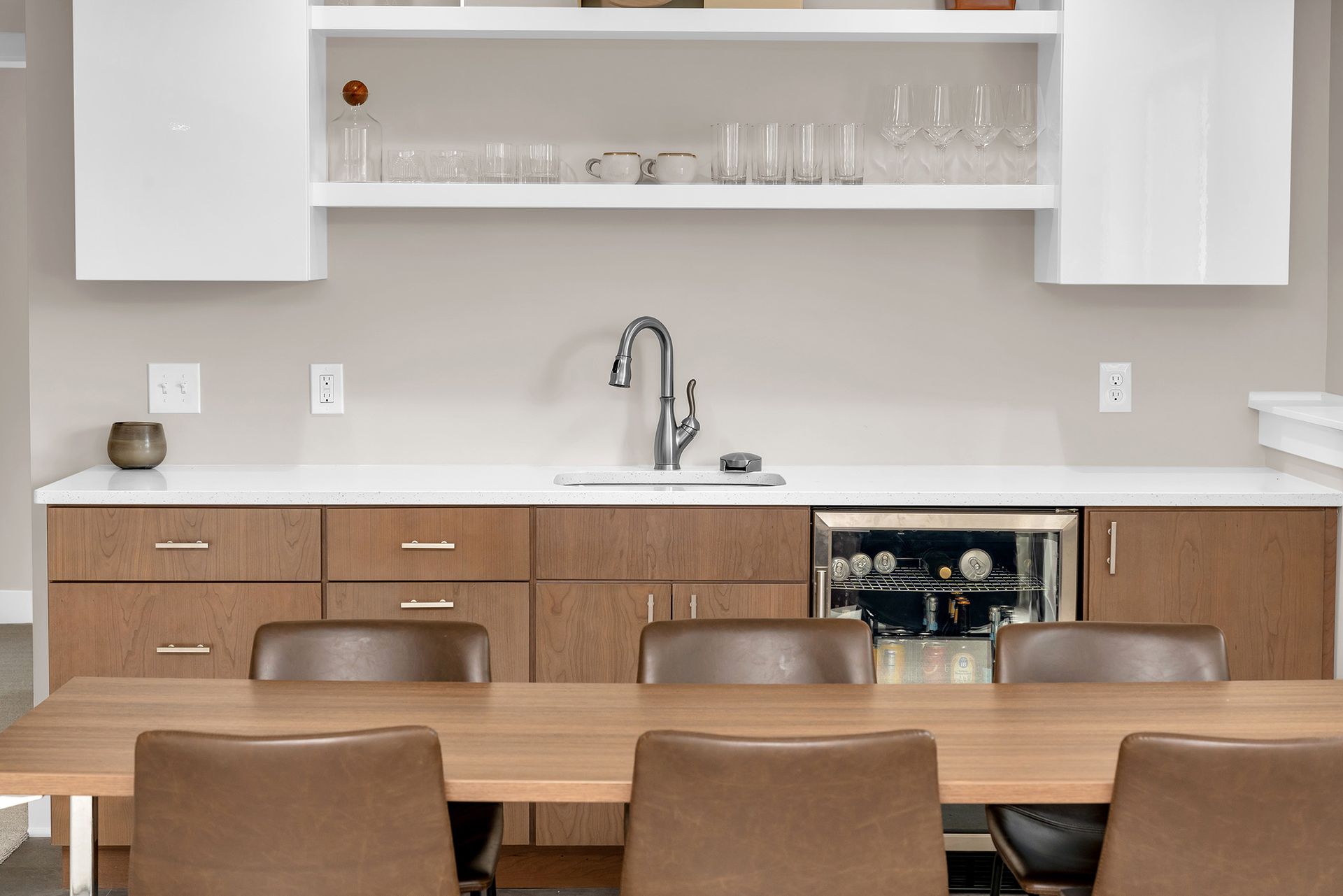 A kitchenette with a table and chairs and a sink.