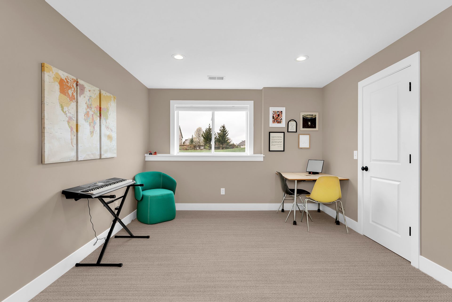 A room with a piano , chair , desk and window.