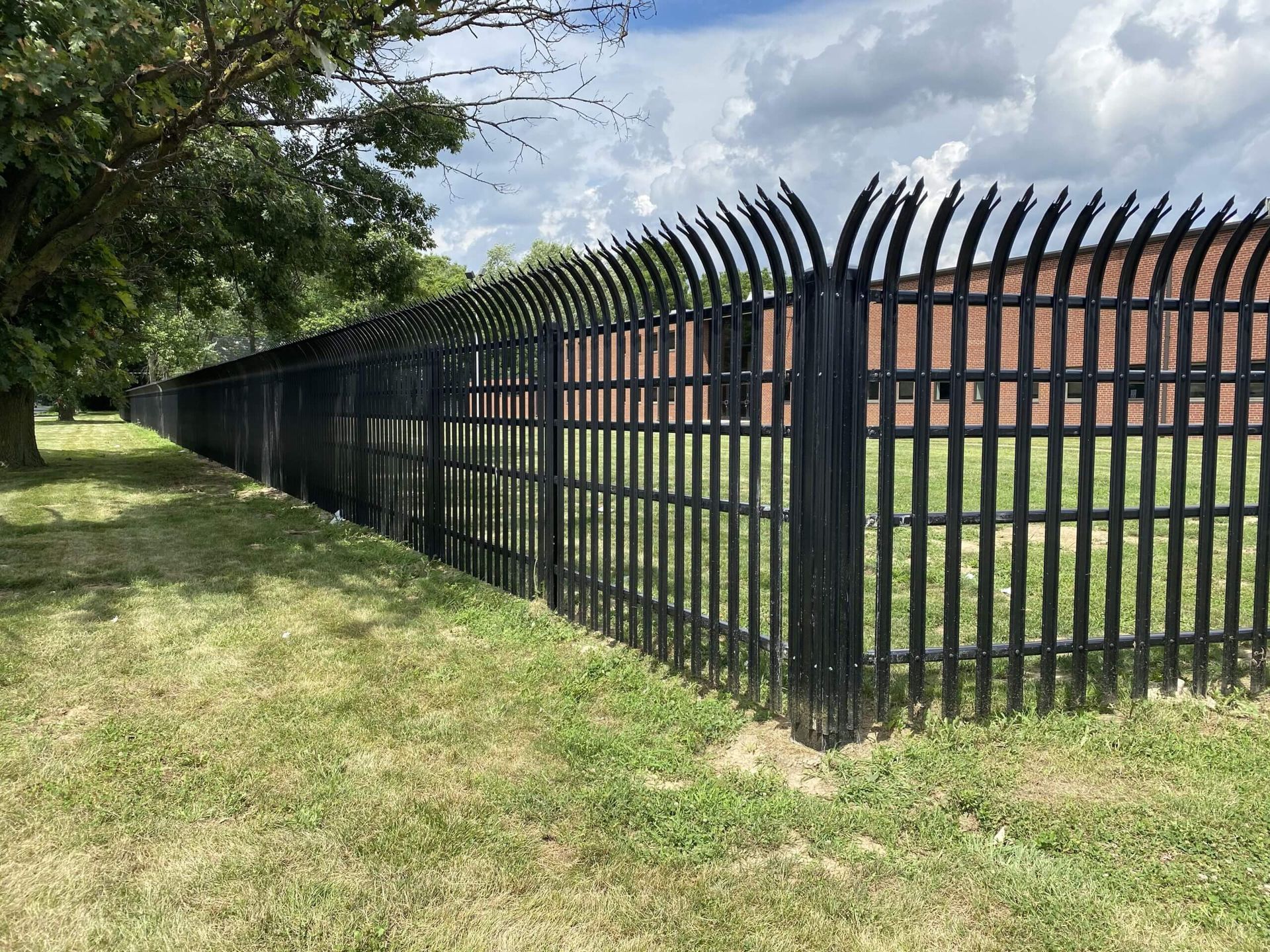 A truck is parked on the side of the road next to a fence.