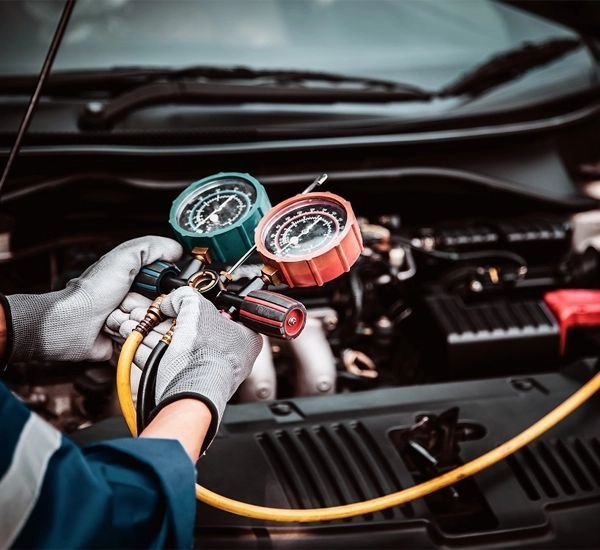 Mechanic testing a vehicle air conditioner - AC repair