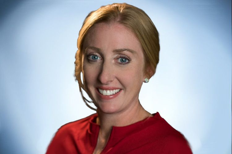 Smiling woman in a red top against a blue studio background
