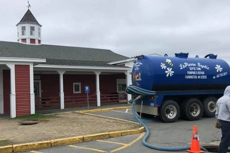 Large septic pumping truck in front of Alton, NH building
