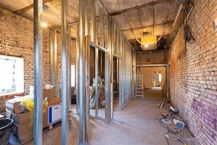 A room under construction with brick walls and metal frames.