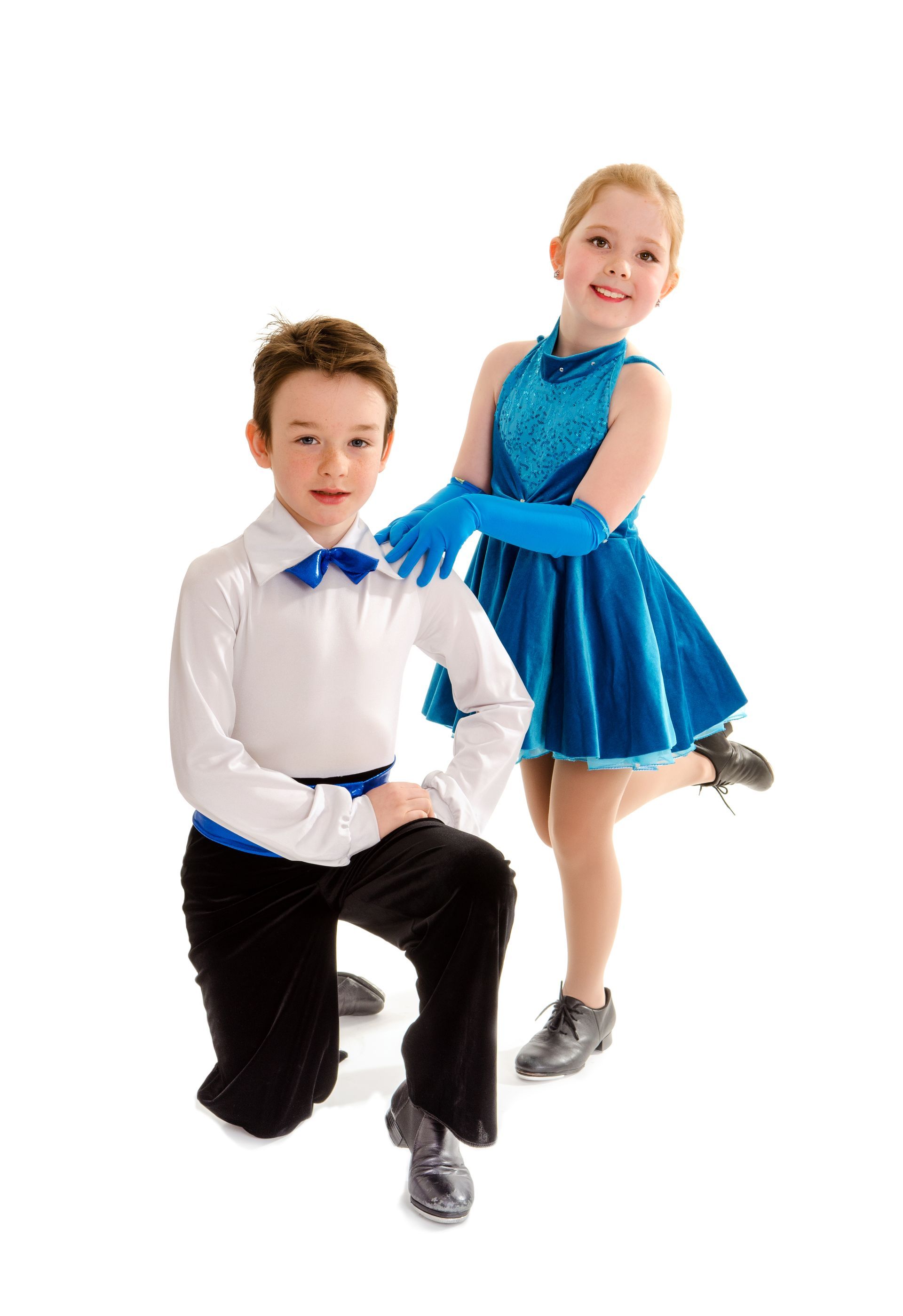 Boy kneeling, girl standing; both in dance attire, smiling. Boy in white shirt, black pants, blue bow tie. Girl in blue dress and gloves.