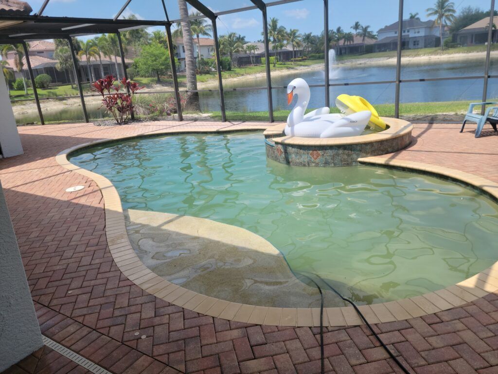 Swimming pool with swan float and brick patio