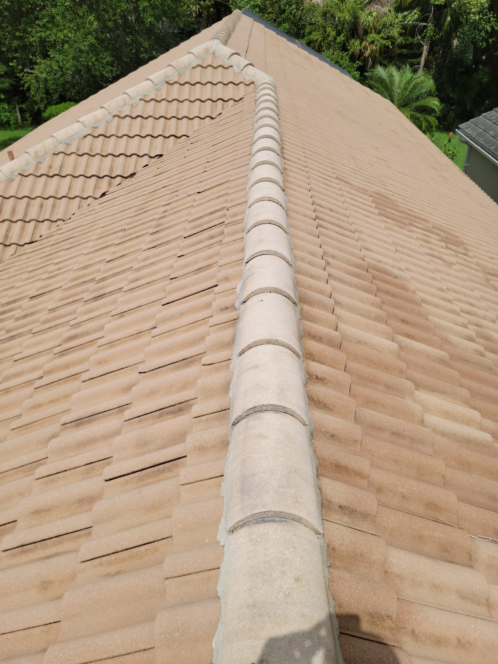 Tan tile roof with a ridge cap, viewed from above.
