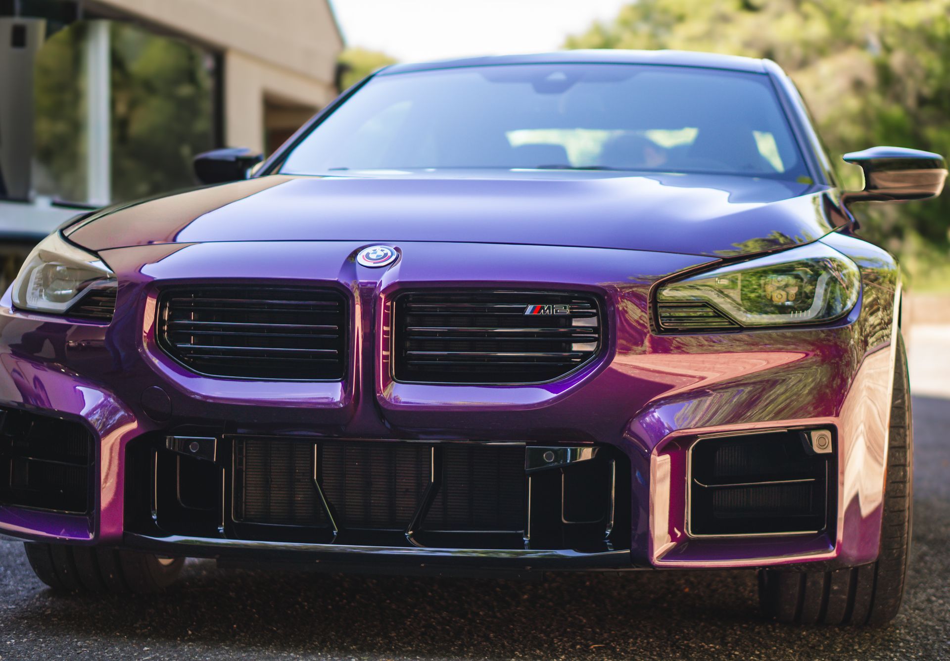 Purple BMW M2 sports car parked outdoors.