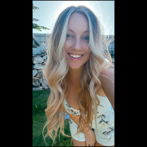 Woman with long, wavy blonde hair smiles outdoors in sunlight — Gold Medal Gymnastics In Molendinar, QLD