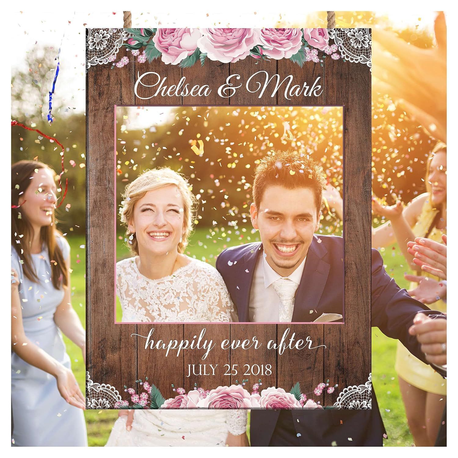 Wedding photo frame prop reading “Chelsea & Mark” and “happily ever after,” held by smiling guests outdoors
