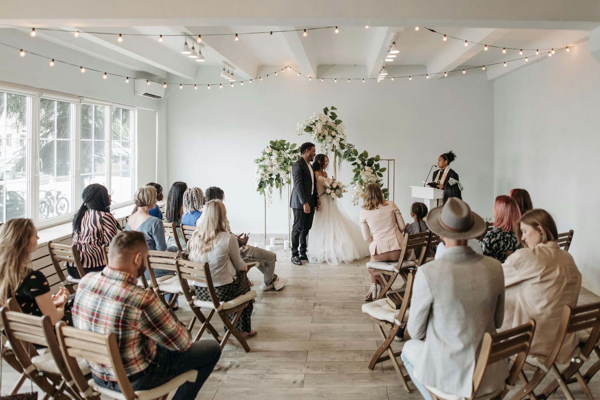 Small wedding ceremony near Penrith in a bright room with seated guests and a couple at the altar