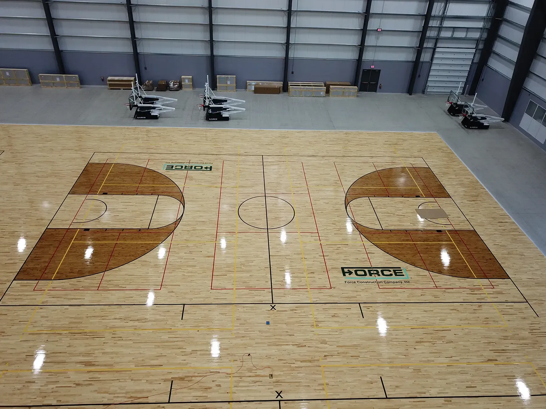 The Force Construction logo painted on basketball courts at the Circle-K Fieldshouse at NexusPark.