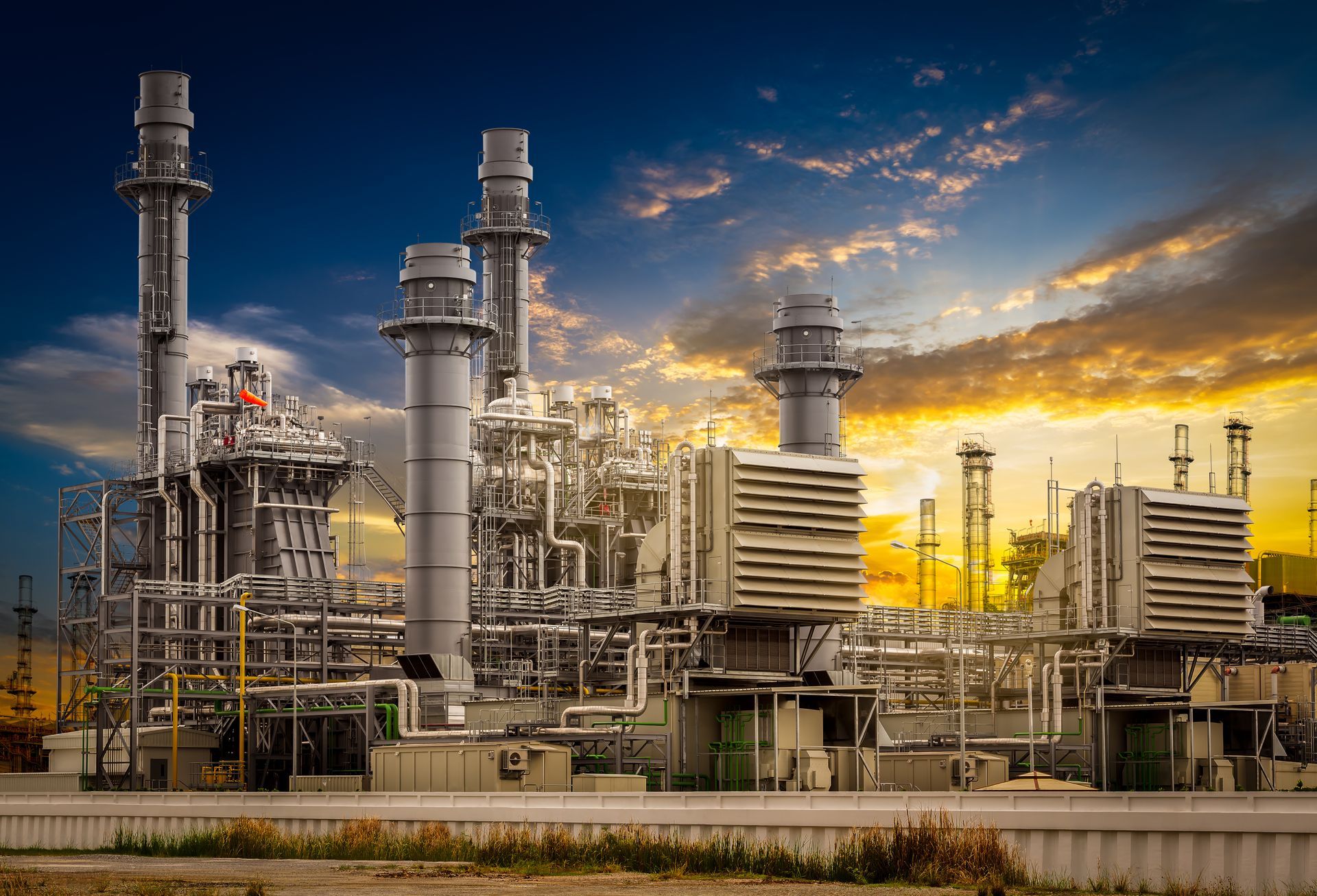 a large industrial plant with a sunset in the background .