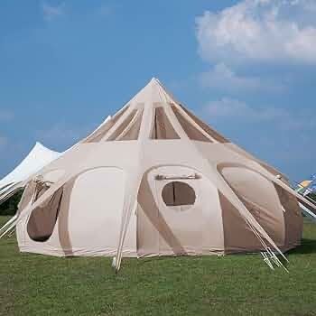 A large tent is sitting on top of a lush green field.