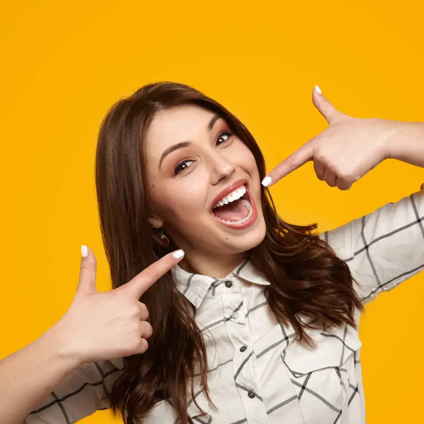 A woman is pointing at herself with both hands on a yellow background.