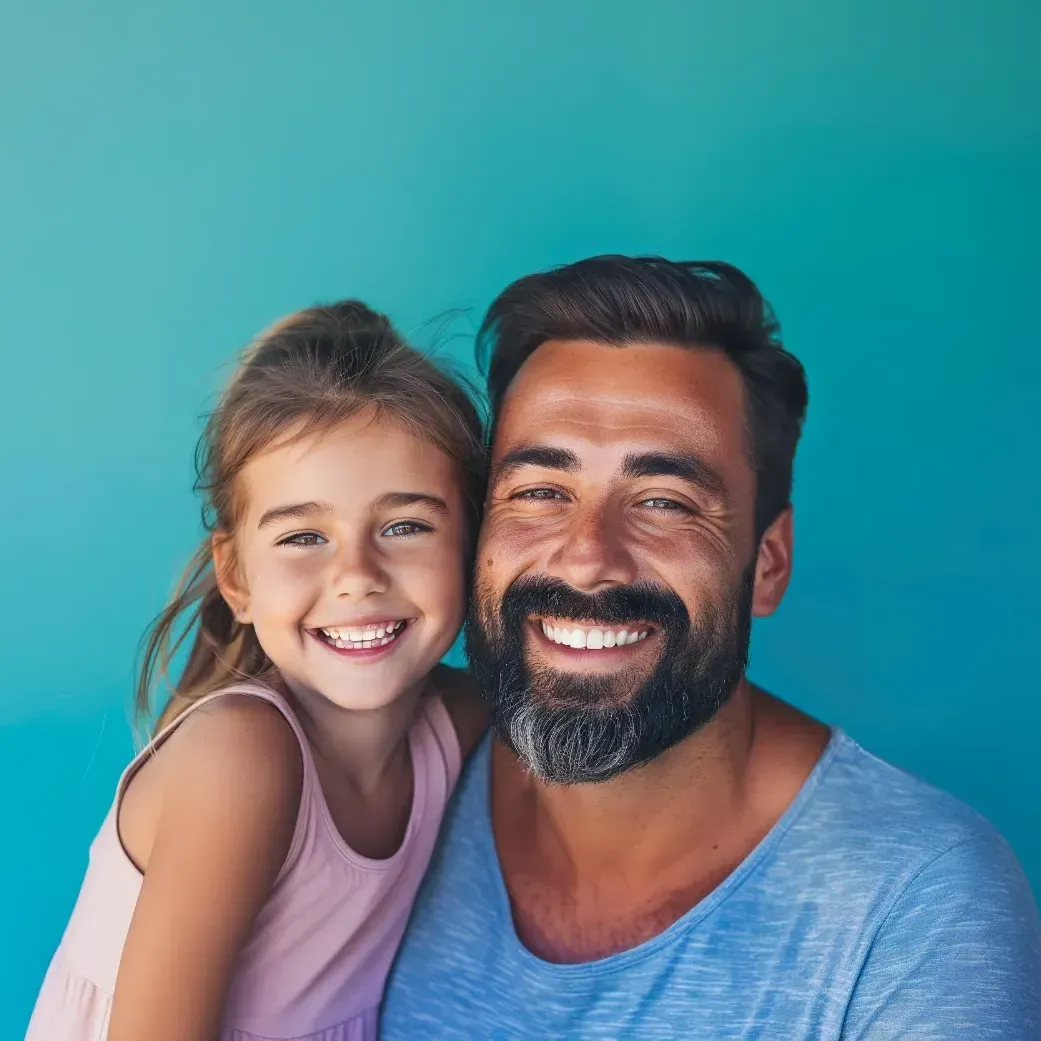 A man with a beard is holding a little girl in his arms.