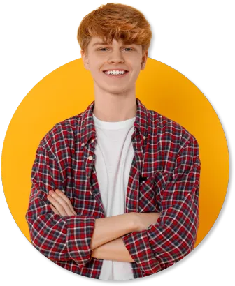 A young man with red hair is standing with his arms crossed and smiling.