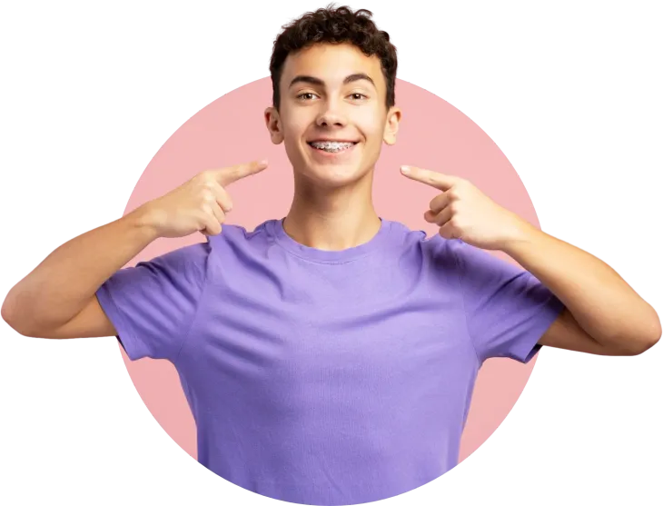 A young man wearing braces is pointing at himself.