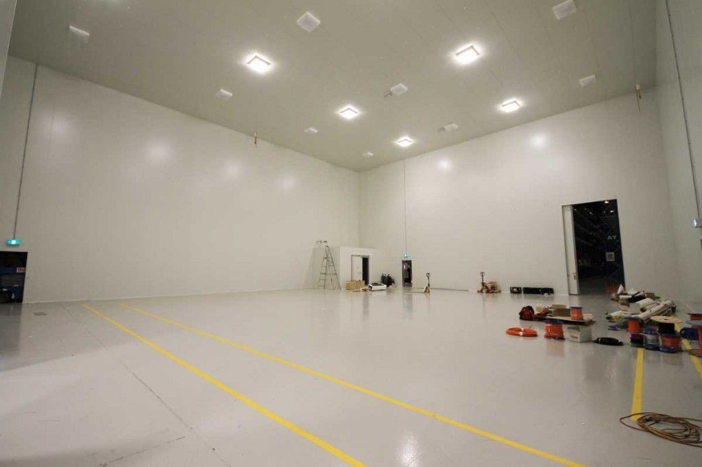 Large empty industrial cool room with white walls, overhead lights, and yellow floor lines.