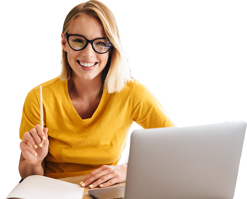 A woman is sitting at a desk with a laptop and a notebook.