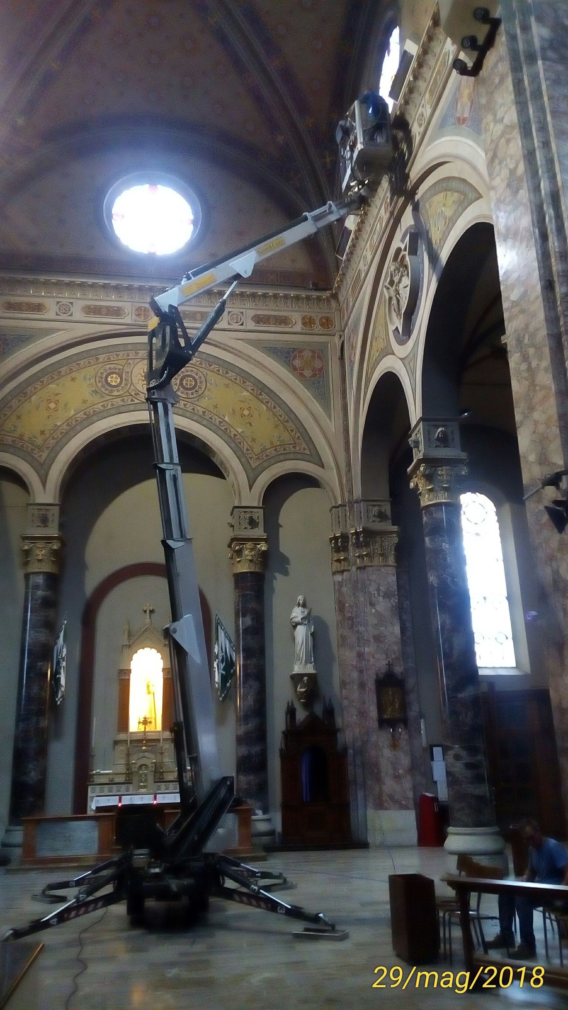 All'interno di una chiesa, un'alta gru si protende verso il soffitto per la manutenzione.