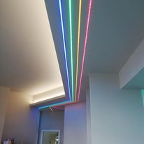 Soffitto con illuminazione da incasso e strisce luminose a LED colorate.
