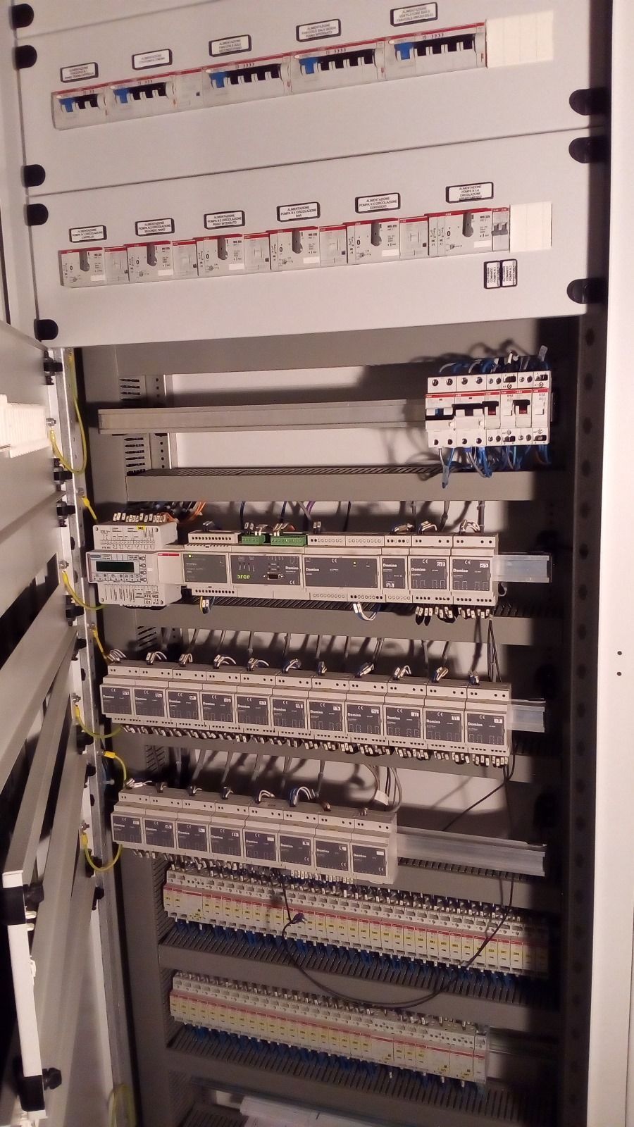 Quadro elettrico con interruttori automatici, relè e cablaggio.