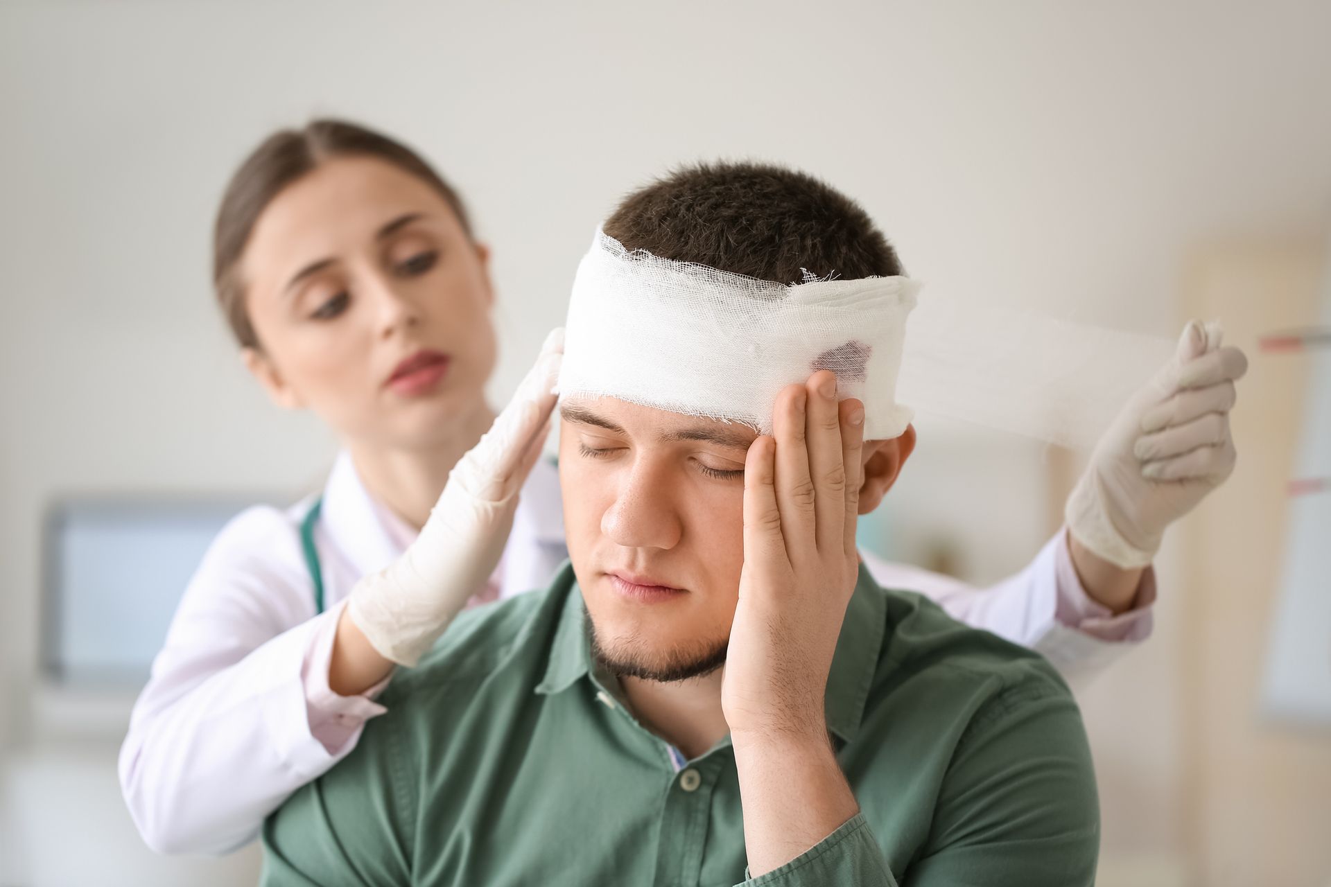 A man with a bandage on his head is being examined by a doctor.
