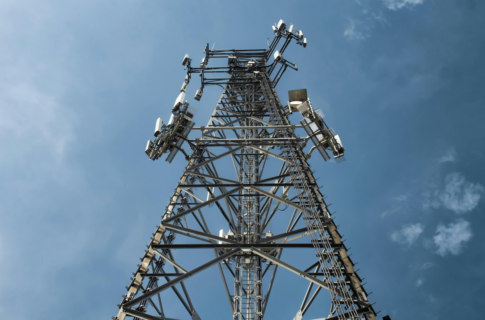 A large metal tower with antennas on it against a blue sky
