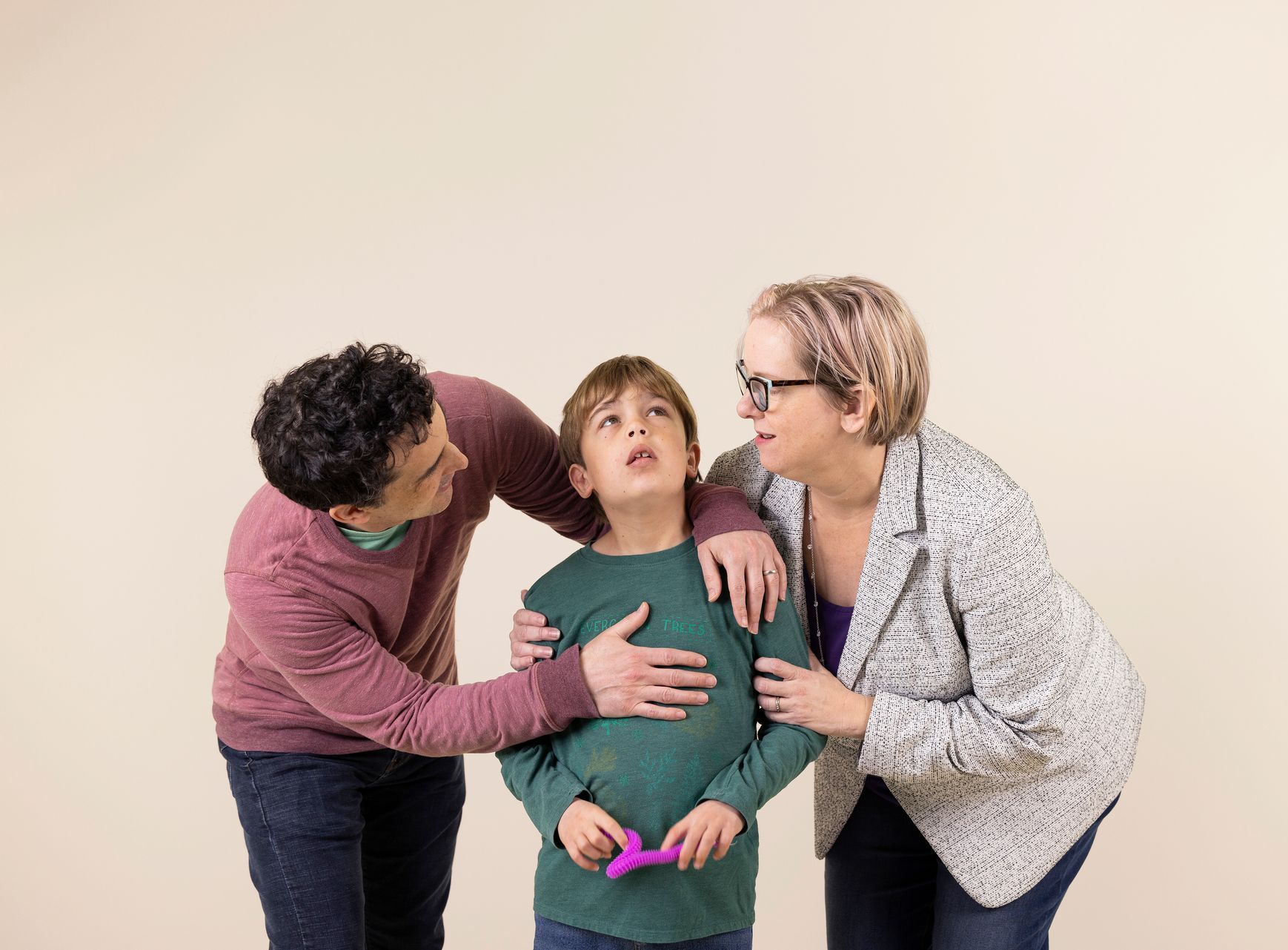A man and a woman are standing next to a young boy.
