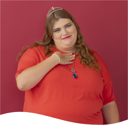 A woman in a red shirt is wearing a necklace and a tiara
