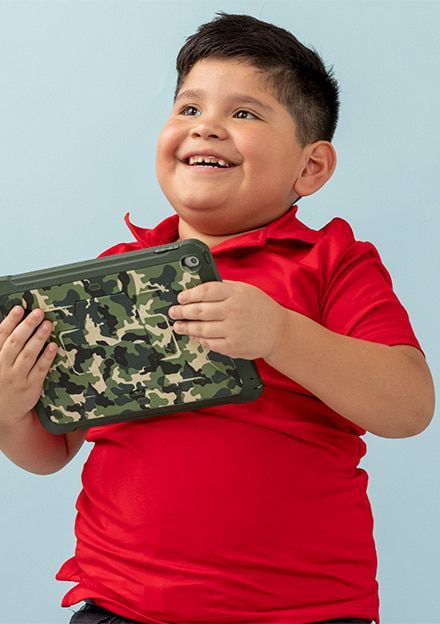 A young boy in a red shirt is holding a camouflage purse.
