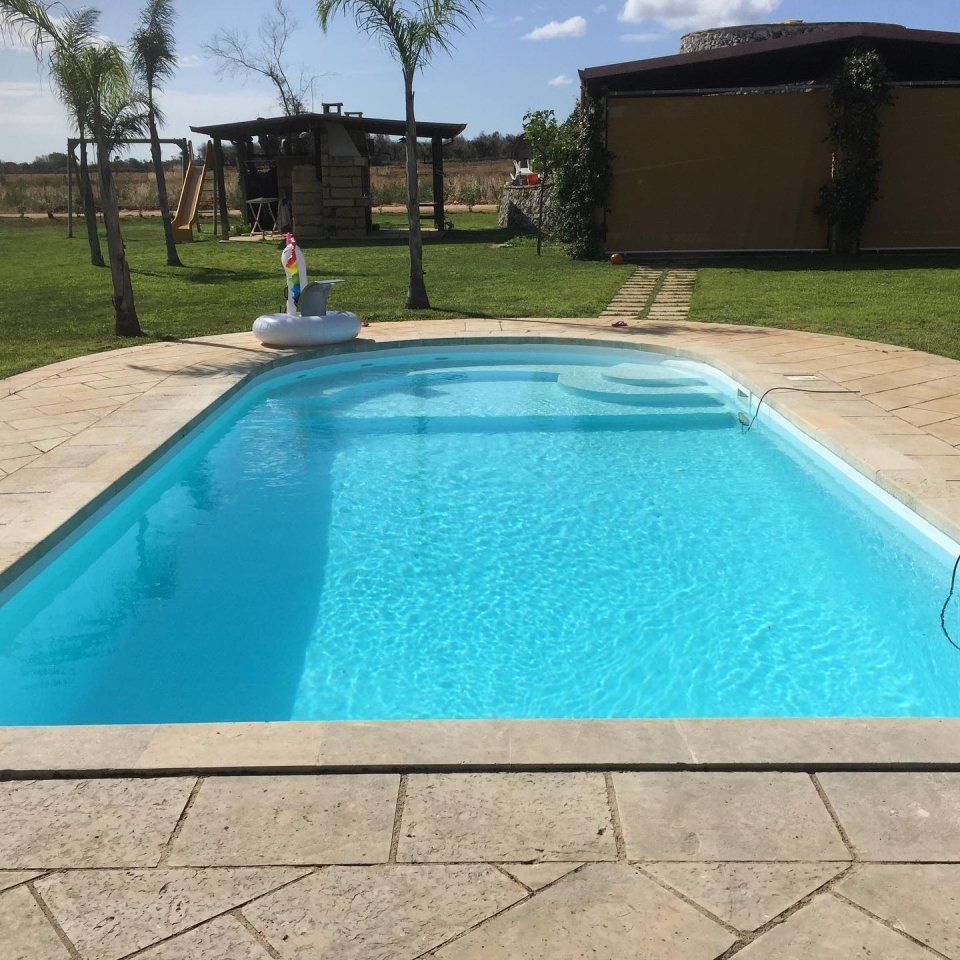 piscina interrata con skimmer in giardino privato con area relax