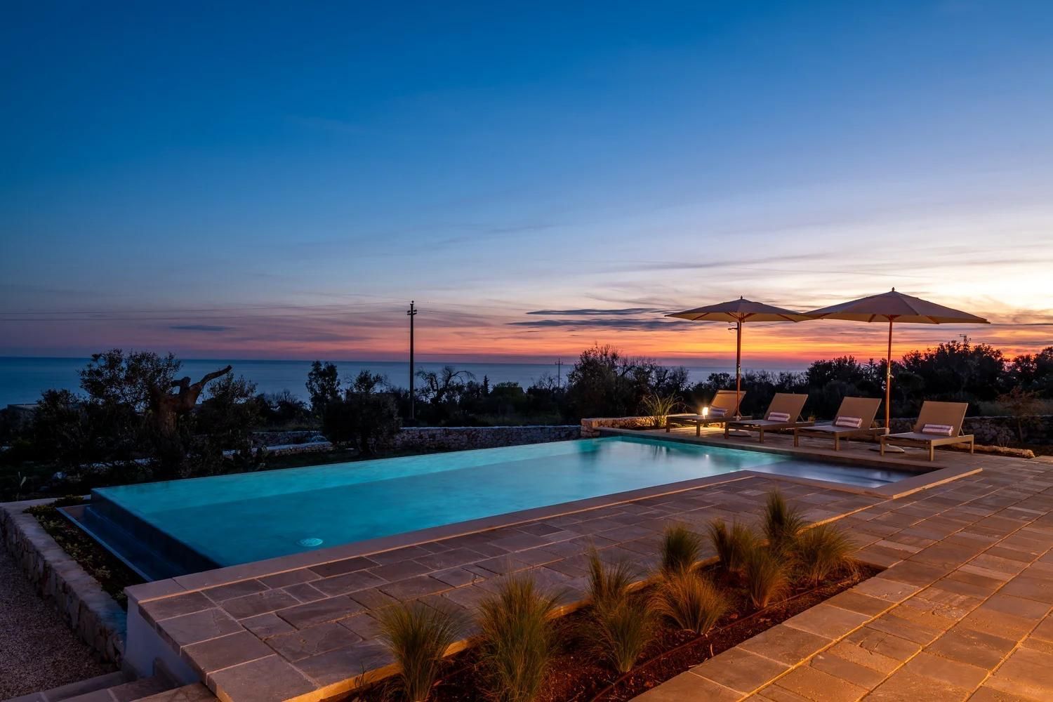 piscina a sfioro infinity di sera con telo interno vogue urban pool design group