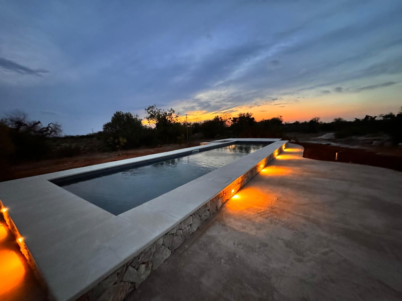 piscina interrata con skimmer in giardino