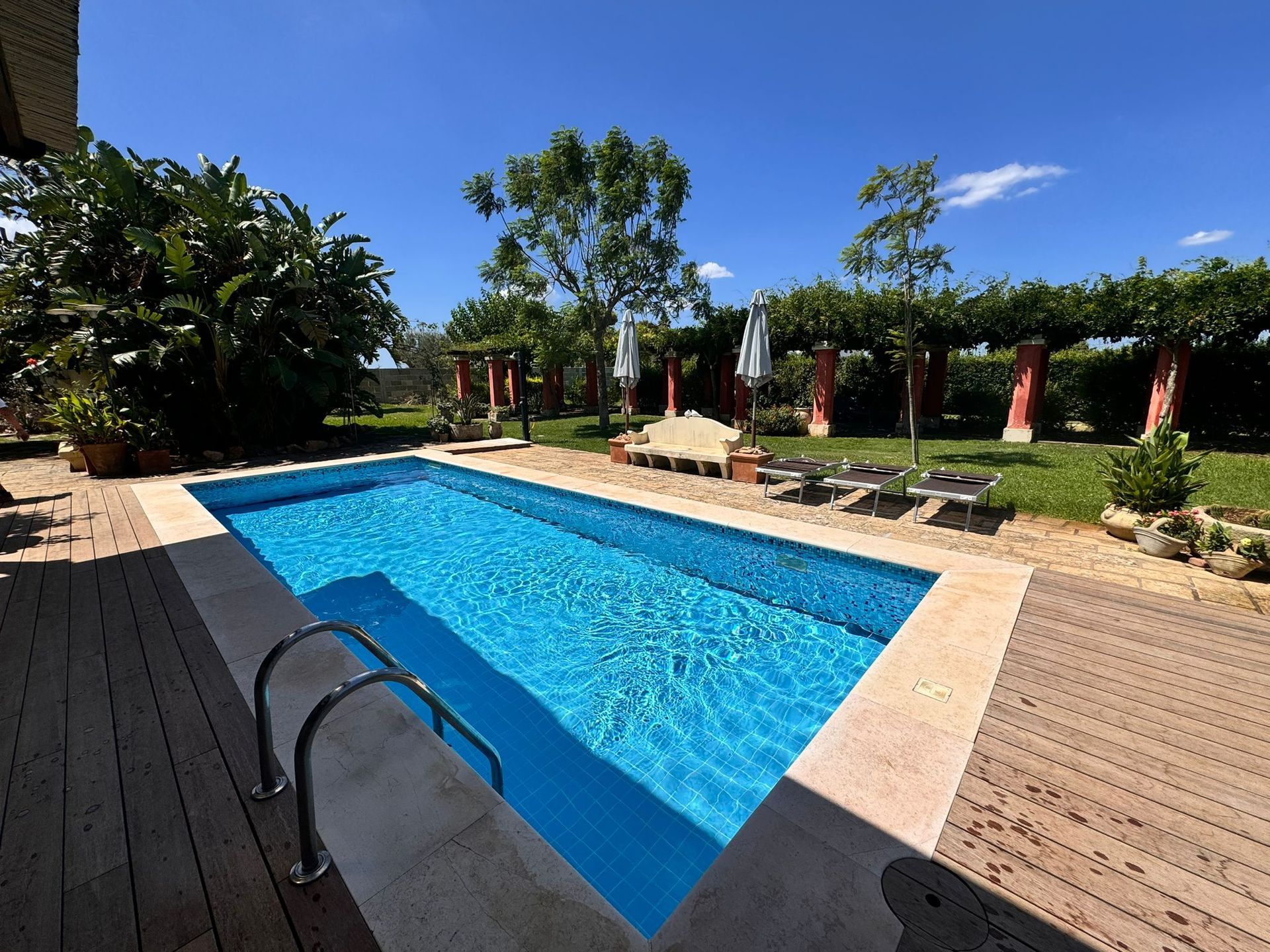 piscina interrata con skimmer in giardino con mosaico asper studio azzurro pool design group