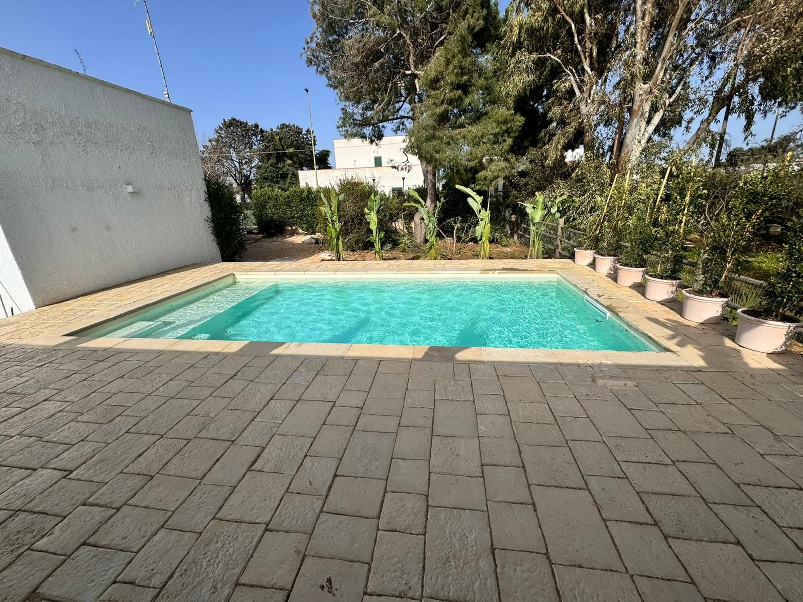 piscina interrata con skimmer in giardino con opannelli d'acciaio pool design group