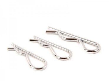 Três grampos em forma de R, de cor prateada e tamanhos variados, dispostas diagonalmente sobre um fundo branco.
