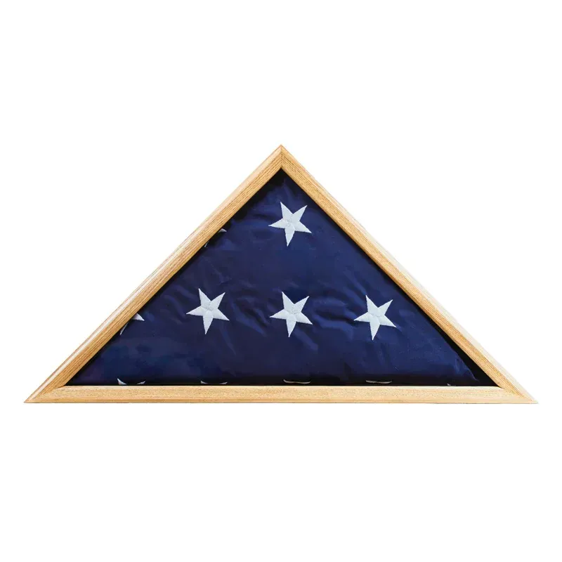 Folded American flag with white stars in a wooden triangular display case.