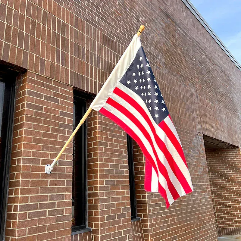 American flag on a white background, mounted on a pole and angled upward
