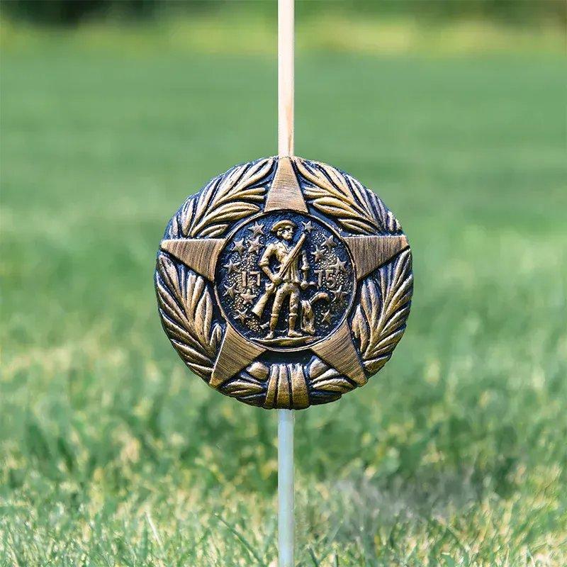 Bronze circular medal with a central figure and laurel wreath border