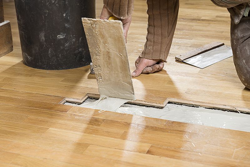 Carpenter Applying Parquet Glue