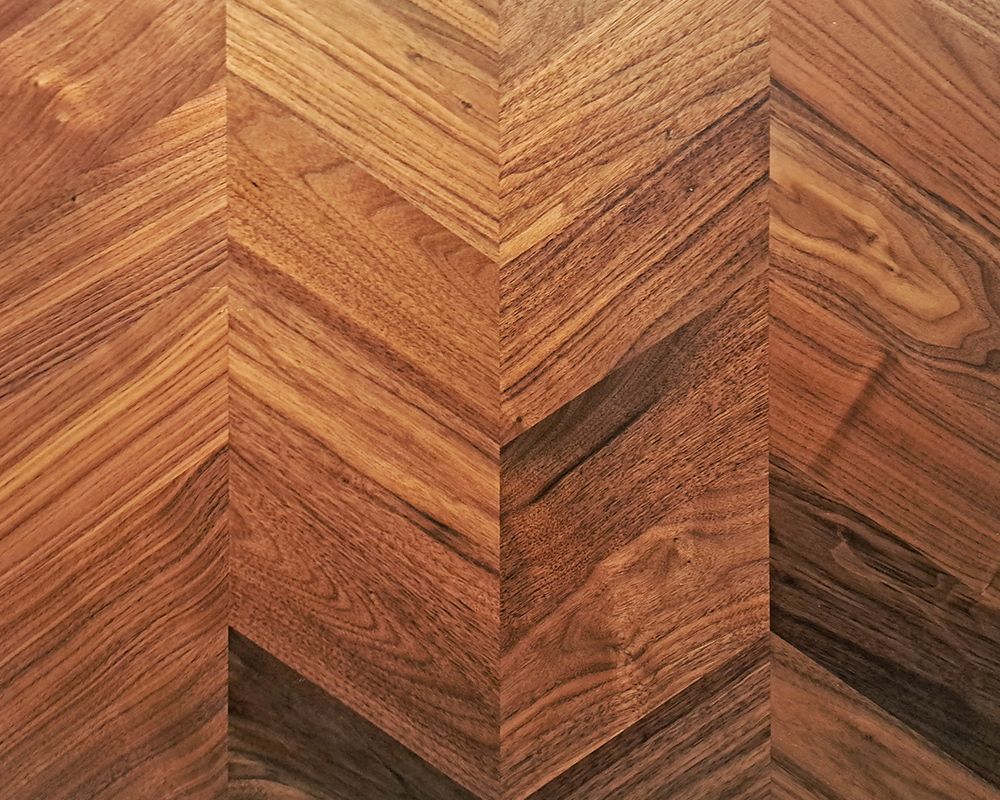 A close up of a wooden floor with a chevron pattern