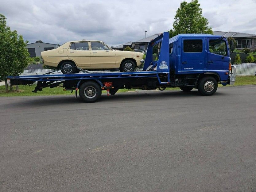 A Blue Tow Truck With a Car on the Back of It — TNT Towing - Coffs Clarence in Yamba, NSW