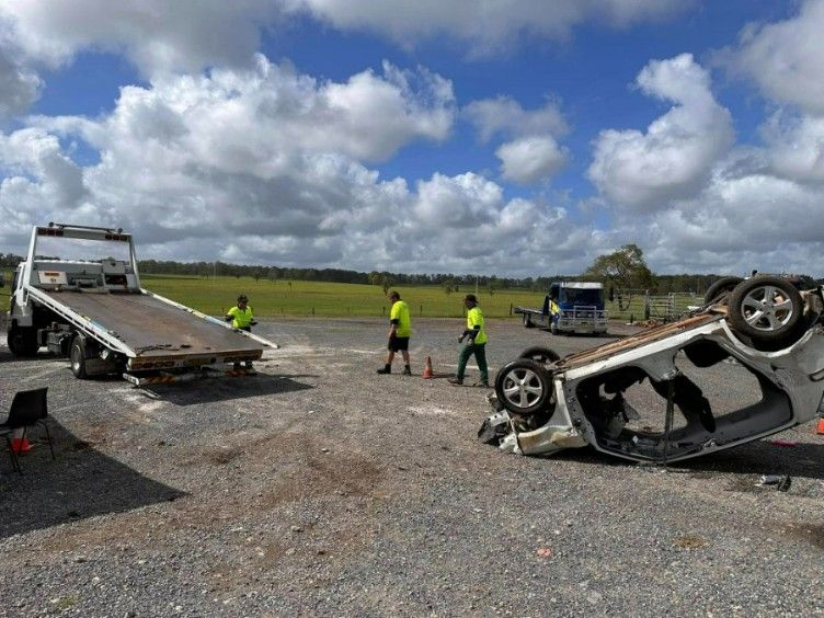 A Tow Truck is Towing a Car on Its Side — TNT Towing - Coffs Clarence in Coffs Harbour, NSW