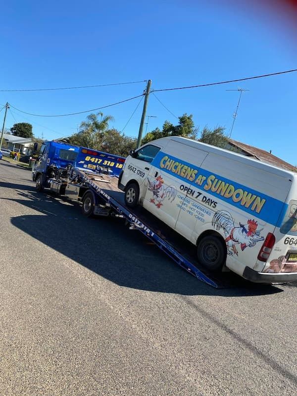 A White Van is Being Towed by a Tow Truck — TNT Towing - Coffs Clarence in South Grafton, NSW