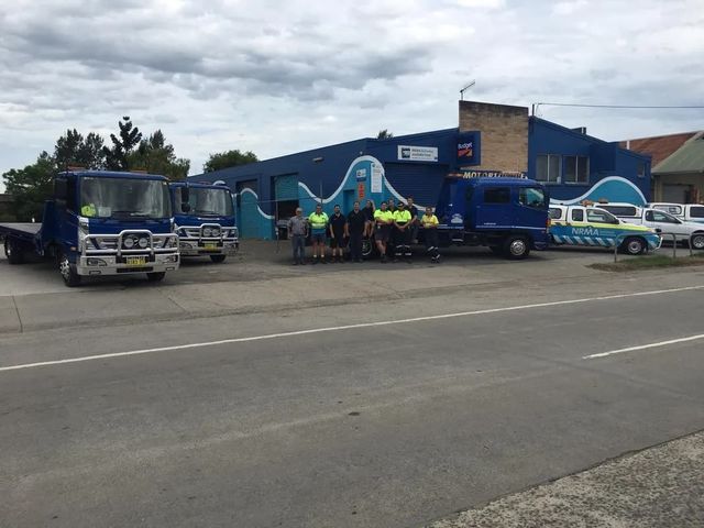 A Green Car is Being Towed by a Tow Truck — TNT Towing - Coffs Clarence in South Grafton, NSW