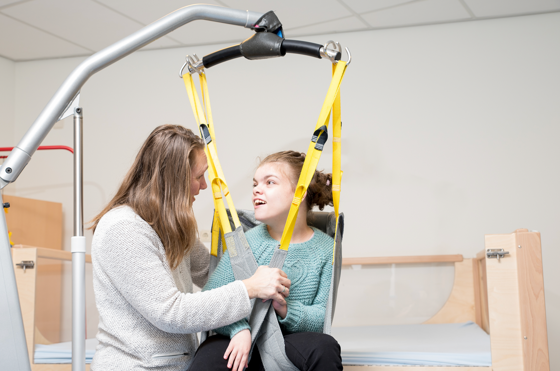 A woman is helping a young girl in a lift.