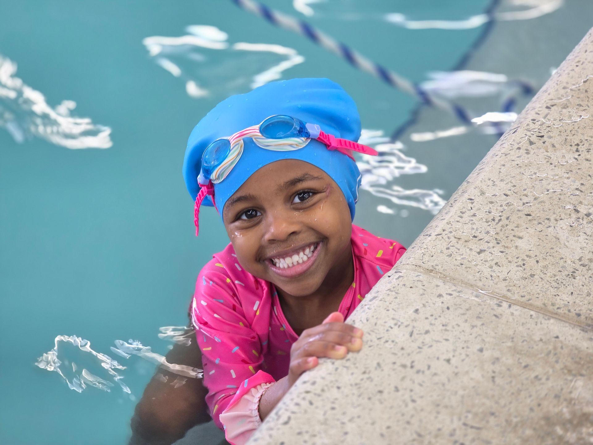 A woman is teaching a young boy how to swim in a swimming pool.
