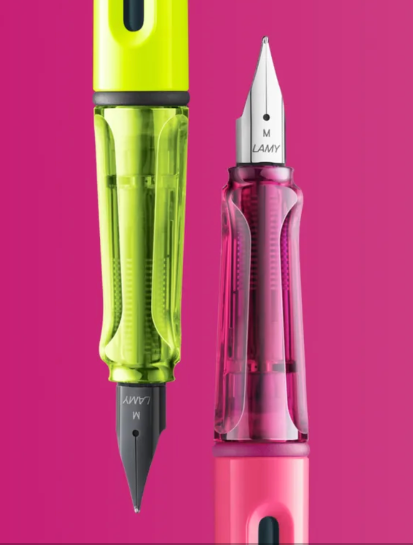 Two colorful fountain pens, one neon green and one pink, on a bright pink background