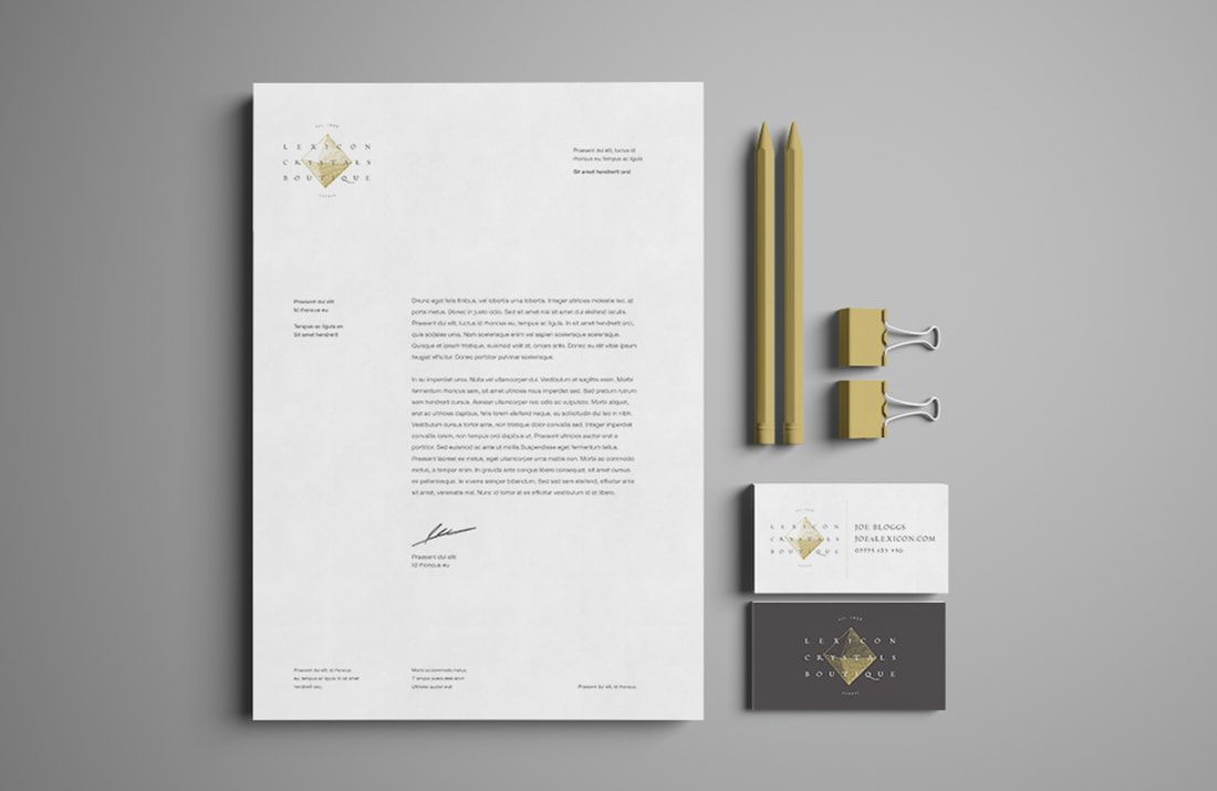 Luxury stationery set with white letterhead, gold pens, business cards, and dark envelope on a light background